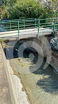 A bridge over a small stream of water under a bridge