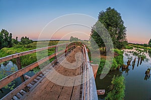 Bridge over a swampy river in sunset time