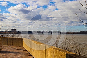 A bridge over the vast waters of the Mississippi river with blue sky and powerful clouds at sunset at Mud Island Park