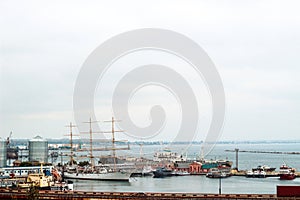 bridge passing through the river against the background of ships and boats on the pier.