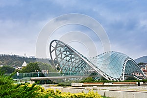 Bridge of Peace - a bow-shaped pedestrian bridge of steel and glass construction illuminated with numerous LEDs over the Kura