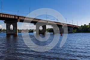 Bridge on a river against a blue sky and clouds