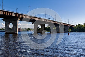 Bridge on a river against a blue sky and clouds