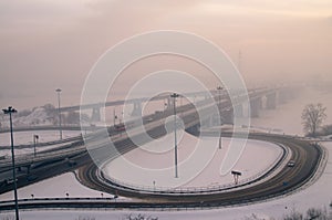 Bridge and road junction in winter fog Russia