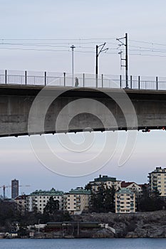 Bridge situated in a suburban area, with a few buildings visible in the background