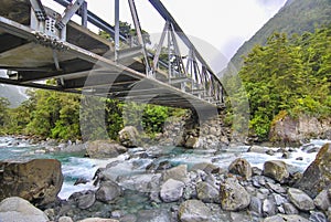 Bridge spanning a clear blue running stream