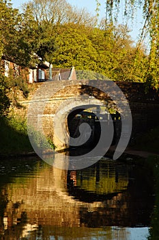 Bridge spanning Shropshire Union canal reflected with trees