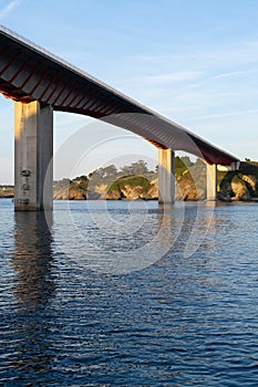 A bridge spans a body of water, with a view of the sky in the background