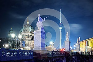 Bridge with stone statues near Belin Cathedral illuminated at night, Germany photo