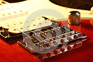Bridge - Tailpiece and Humbucker Pickup Machine of an electric guitar stratocaster with pegs and strings. Artistic photo of a