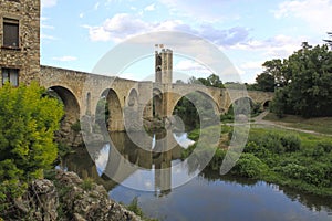 Bridge and a tower over a river and its reflection