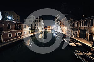 Bridge and water view over a canal in Venice at calm night