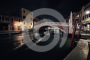 Bridge and water view over a canal in Venice at calm night