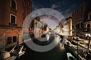 Bridge and water view over a canal in Venice at calm night