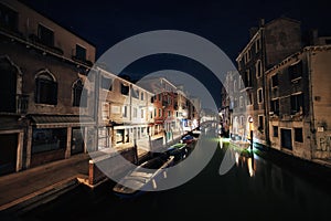 Bridge and water view over a canal in Venice at calm night