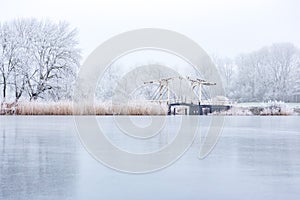 Bridge and white frozen trees in fairytale atmosphere on the bosbaan in the Amsterdamse Bos