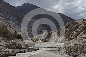 Bridge on Zanskar river flowing through gorge in ladakh landscape