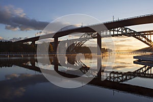 Bridges reflected in water at beautiful, early dawn.