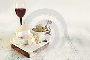 brie, camembert, gorganzola with olives and cherry tomatoes. Soft cheese with white and blue mold, olives and olive oil