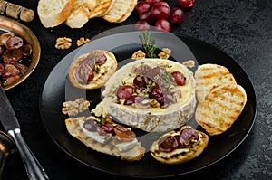 Brie cheese baked with nuts and grapes