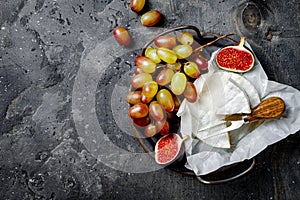 Brie cheese, figs, green grapes. Wine appetizers, antipasti snacks. Cheese and fruit platter