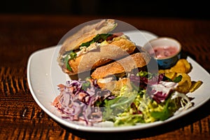 Brie and salad sandwiches with coleslaw, mixed green salad and crisps
