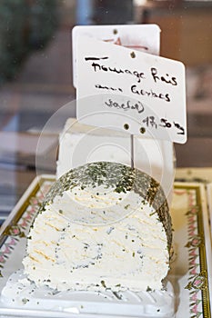 Brie type of cheese. Camembert cheese. Fresh Brie cheese and a slice on a wooden board with nuts