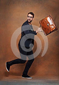 Briefcase, fashion and man in studio with glasses for trendy, edgy and stylish outfit with confidence. Goofy, satchel