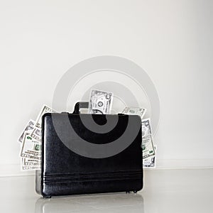 Briefcase overflowing with money photo