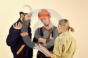 Woman amend plan of repair. Supervisor not satisfied with renovation. Brigade of workers, builders in helmets, repairers photo