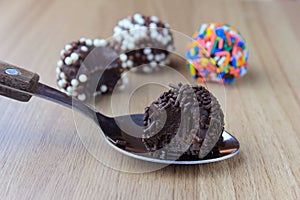 Brigadeiro brigadier, sweet chocolate typical of Brazilian cuisine covered with particles, in a wooden background