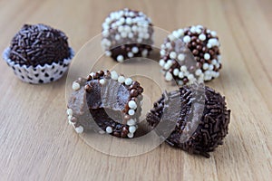 Brigadeiro brigadier, sweet chocolate typical of Brazilian cuisine covered with particles, in a wooden background