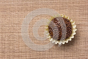 Brigadeiro is a chocolate truffle from Brazil. Cocoa and sprinkles of chocolate. Children birthday party sweet. Flat lay design o