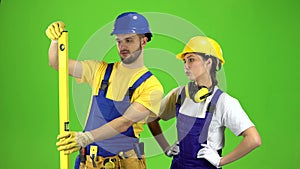 Brigadier holds a building level in his hands and measures the surface. Green screen