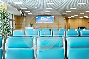 Bright and airy airport lounge with rows of turquoise seats arranged neatly