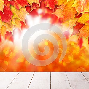 Bright autumn background. Red fall maple leaves and abstract bokeh light with empty white wooden board background