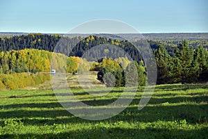 Bright autumn colors of the surroundings of the highway through the Ural forests and mountains. Sunny autumn days in the foothills