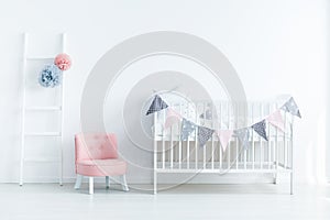 Bright baby room interior with a crib decorated with triangles o