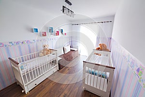 Bright baby room with white cradles