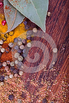 Bright background with different spices on dark wood