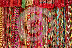 Bright background of handmade strands of colorful beads at outdoor crafts market in Kathmandu, Nepal.