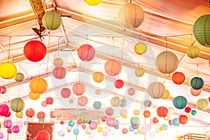 Bright background with many colorful chinese round lantern decorating the ceiling of hall at celebrating event, festival, party. P