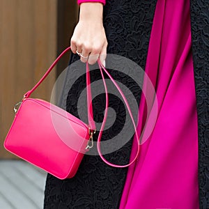 A bright bag in women`s hands. Leather bag.