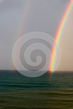 Bright beautiful colorful double rainbow over the sea