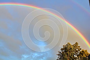 Bright beautiful real double rainbow in cloudy sky