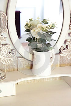 Bright bedroom, a vase of roses by the mirror. The damned room. White bedroom interior
