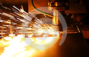 Bright blaze and sparkles while automated laser device cutting steel