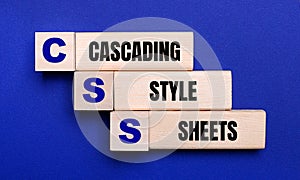 On a bright blue background, light wooden blocks and cubes with the text CSS Cascading Style Sheets