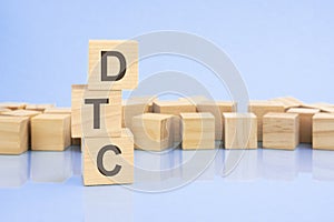 on a bright blue background, light wooden blocks and cubes with the text DTC