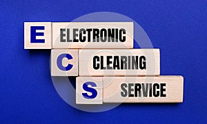 On a bright blue background, light wooden blocks and cubes with the text ECS Electronic Clearing Service